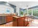 Open kitchen with wood cabinetry, granite island with sink, and view to the living room with fireplace at 1009 Anduin Falls Dr, Charlotte, NC 28269