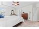 Bright main bedroom featuring a tray ceiling, ceiling fan, and classic wood furnishings at 1009 Anduin Falls Dr, Charlotte, NC 28269