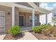 Charming front porch with brick facade, white columns, and manicured landscaping, creating a welcoming entry at 1020 Clementine Rd, Monroe, NC 28110