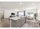 Open kitchen featuring gray island, white countertops, and stainless steel appliances flowing to dining and living spaces at 1020 Clementine Rd, Monroe, NC 28110