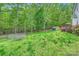 Expansive backyard featuring a lush lawn, wooden deck, and mature trees at 10836 Maryanna Ct, Charlotte, NC 28213