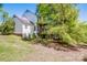 Back of a two story home featuring an upper and lower wooden porch with large mature trees surrounding at 11024 Hunters Trace None, Charlotte, NC 28262