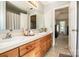 Bathroom with dual sinks, wooden cabinets, and a shower at 11024 Hunters Trace None, Charlotte, NC 28262