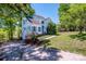 Charming two-story home featuring light siding, blue shutters, mature trees and vibrant flowering bushes in the front yard at 11024 Hunters Trace None, Charlotte, NC 28262