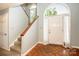 Bright foyer featuring wood floors and a staircase with a large arched window above door at 11024 Hunters Trace None, Charlotte, NC 28262