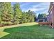 Large backyard with manicured lawn, mature trees, and a wooden deck, perfect for outdoor activities at 1105 Hoyle Ln, Waxhaw, NC 28173