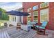 A beautiful outdoor living space with a dark wood deck, a gray rug, and comfortable seating under a large umbrella at 1105 Hoyle Ln, Waxhaw, NC 28173