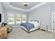 Relaxing main bedroom features a tray ceiling, soft carpet, and three windows at 1105 Hoyle Ln, Waxhaw, NC 28173