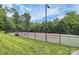 A community tennis court with a black fence, green grass, and trees in the background at 1105 Hoyle Ln, Waxhaw, NC 28173
