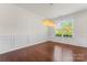 Dining room featuring hardwood floors, wainscoting detail, a modern light fixture, and a large window at 112 Serravista St, Mooresville, NC 28117