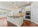 Open kitchen featuring pendant lighting, double ovens, tile backsplash, and a center island with granite counters at 112 Serravista St, Mooresville, NC 28117