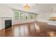 Bright, open living room with a fireplace, hardwood floors, and an ornate chandelier at 112 Serravista St, Mooresville, NC 28117