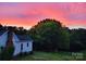 Lovely sunset view of a charming home surrounded by large green trees, creating a peaceful and private setting at 1165 Old Salisbury Concord Rd, Concord, NC 28025