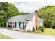 Exterior view of a charming white home with a blue door, porch seating, and well-maintained landscaping at 1165 Old Salisbury Concord Rd, Concord, NC 28025