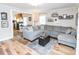 Cozy living room with a large sectional sofa, wood floors, and decoratively framed pictures with a glimpse into the adjoining kitchen at 1165 Old Salisbury Concord Rd, Concord, NC 28025