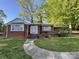 Charming brick home with a walkway leading to the front door, complemented by mature trees and a covered carport at 1218 Forestdale Dr, Salisbury, NC 28144