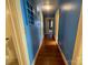 Hallway with hardwood floors, blue walls, and access to other rooms at 1218 Forestdale Dr, Salisbury, NC 28144