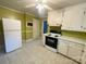 Compact kitchen with white appliances, neutral tile flooring, and green walls, offering a functional space at 1218 Forestdale Dr, Salisbury, NC 28144