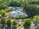 Aerial view showcasing community pool, clubhouse, tennis courts, and lush landscaping at 12404 Mcallister Park Dr, Charlotte, NC 28277