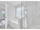 Bright bathroom boasts a garden tub with glass block window and a separate shower at 12404 Mcallister Park Dr, Charlotte, NC 28277