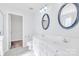 Bathroom featuring double sink vanity, with framed mirrors and view of walk-in closet at 12404 Mcallister Park Dr, Charlotte, NC 28277