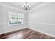 Bright dining room with large window and decorative lighting, highlighting hardwood floors at 12404 Mcallister Park Dr, Charlotte, NC 28277