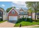 Beautiful brick home with bright blue shutters, a well-manicured lawn, and attached two-car garage at 12404 Mcallister Park Dr, Charlotte, NC 28277