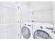 Bright laundry room featuring modern, front-load LG washer and dryer, plus storage shelves and a white door at 12404 Mcallister Park Dr, Charlotte, NC 28277