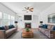 Bright living room with a fireplace, built-in shelves, and comfortable seating with wood floors at 12404 Mcallister Park Dr, Charlotte, NC 28277