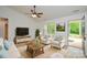 Bright living room features a sofa, multiple arm chairs, large TV, ceiling fan and outside view at 164 Hillndale Ln, Statesville, NC 28677