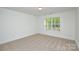 Bright bedroom with neutral carpet, white walls, and large window for natural light at 164 Hillndale Ln, Statesville, NC 28677