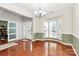 Bright dining room with bay windows, hardwood floors, elegant chandelier, and neutral color palette at 2003 Dataw Ln, Indian Trail, NC 28079