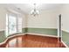 Spacious dining area featuring ample natural light, hardwood floors, and a stylish chandelier at 2003 Dataw Ln, Indian Trail, NC 28079