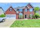 Beautiful brick home featuring manicured lawn, arched windows, black shutters and attached two-car garage at 2003 Dataw Ln, Indian Trail, NC 28079