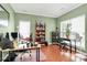 Home office featuring hardwood floors, natural light, a large desk and a green accent wall at 2003 Dataw Ln, Indian Trail, NC 28079