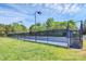 Outdoor tennis court featuring a well-maintained blue surface, enclosed by a fence, and illuminated by lights at 2003 Dataw Ln, Indian Trail, NC 28079