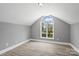 Bedroom featuring high ceilings, light gray walls, an arched window, and light hardwood floors at 2019 Kingston Rd, Kingstown, NC 28150