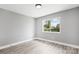 Bedroom featuring neutral walls, white trim, a window with green view, and light hardwood floors at 2019 Kingston Rd, Kingstown, NC 28150