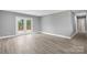 Bright living room with modern wood flooring, fresh gray paint, and french doors to a back porch at 2019 Kingston Rd, Kingstown, NC 28150