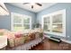 Bedroom with colorful quilt, neutral walls, hardwood floors, and shuttered windows at 206 Oxford Place Dr, Fort Mill, SC 29715