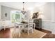 Bright dining room with hardwood floors, an elegant chandelier, and traditional wainscoting for a refined space at 206 Oxford Place Dr, Fort Mill, SC 29715
