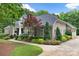 Lovely brick home with pristine landscaping, a curved walkway, and a manicured lawn. Spacious three-car garage included at 206 Oxford Place Dr, Fort Mill, SC 29715