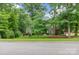 Wooded property featuring a well-maintained lawn and mature trees, creating a serene and private setting. Long driveway at 206 Oxford Place Dr, Fort Mill, SC 29715