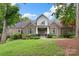 Charming brick home featuring a manicured lawn and well-maintained landscaping, with flowering bushes in the front yard at 206 Oxford Place Dr, Fort Mill, SC 29715