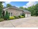 Three-car garage and lush landscaping, featuring colorful flowers and greenery to enhance the home's curb appeal at 206 Oxford Place Dr, Fort Mill, SC 29715