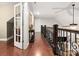 Upstairs hallway showcasing hardwood floors and decorative wrought iron railing at 206 Oxford Place Dr, Fort Mill, SC 29715