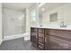 Modern bathroom featuring a glass-enclosed shower and dual vanity with dark wood cabinets at 207 Aspire Cir # 46, Wingate, NC 28174