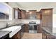 Modern kitchen features stainless steel appliances, granite counters, and dark wood cabinets at 207 Aspire Cir # 46, Wingate, NC 28174