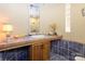 Well-lit bathroom featuring a large mirror, tiled countertop, and charming vanity at 217 W 8Th St, Charlotte, NC 28202