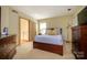 Spacious bedroom with a wooden bed frame, carpet flooring, and natural light at 217 W 8Th St, Charlotte, NC 28202